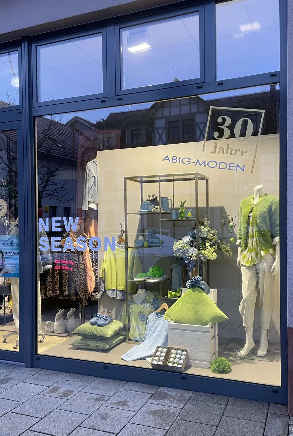 Abig-Moden - Modeboutique - Ein Schaufenster mit einer Schaufensterpuppe in einem grünen Kleid