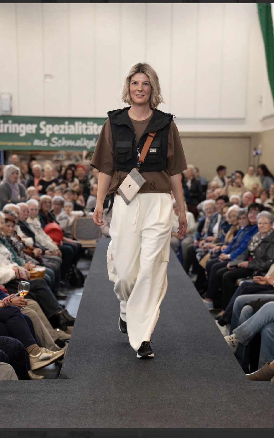 Abig-Moden - Modeboutique - Ein Model mit langen, lockigen Haaren posiert in einem weißen T-Shirt mit dem fettgedruckten schwarzen Schriftzug „LOVE ON TOP“ unter der Überschrift „10 DAYS“.