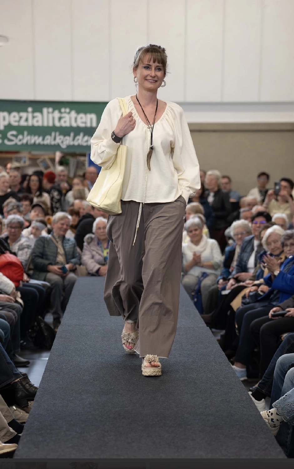 Abig-Moden - Modeboutique - Ein Model mit langen, lockigen Haaren posiert in einem weißen T-Shirt mit dem fettgedruckten schwarzen Schriftzug „LOVE ON TOP“ unter der Überschrift „10 DAYS“.