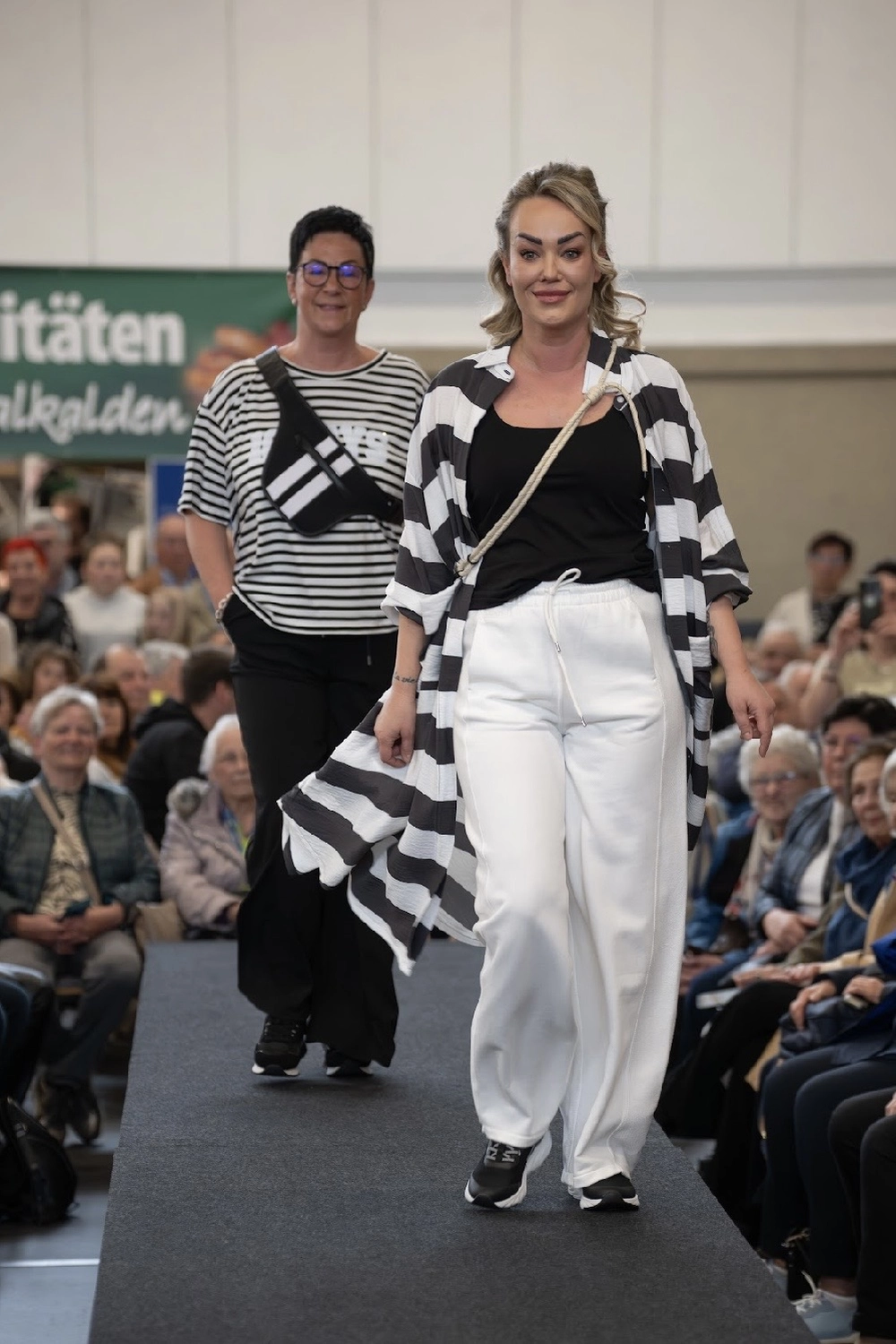 Abig-Moden - Modeboutique - Ein Model mit langen, lockigen Haaren posiert in einem weißen T-Shirt mit dem fettgedruckten schwarzen Schriftzug „LOVE ON TOP“ unter der Überschrift „10 DAYS“.