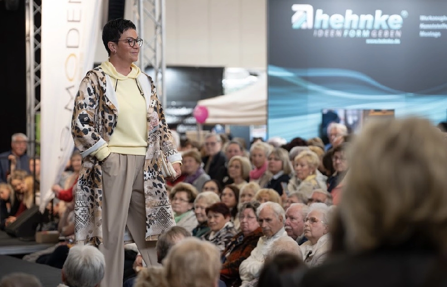 Abig-Moden - Modeboutique - Ein Model mit langen, lockigen Haaren posiert in einem weißen T-Shirt mit dem fettgedruckten schwarzen Schriftzug „LOVE ON TOP“ unter der Überschrift „10 DAYS“.