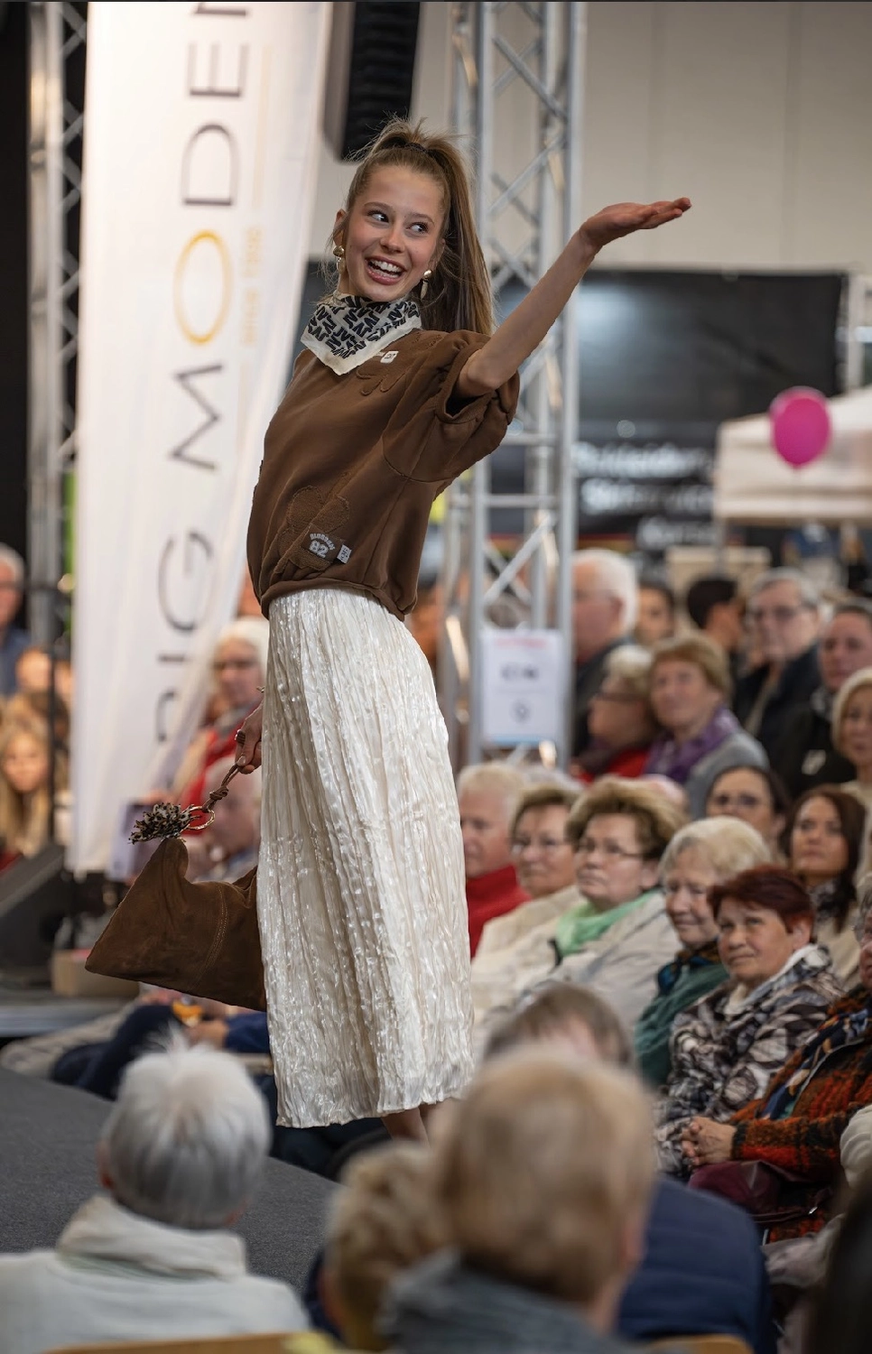 Abig-Moden - Modeboutique - Ein Model mit langen, lockigen Haaren posiert in einem weißen T-Shirt mit dem fettgedruckten schwarzen Schriftzug „LOVE ON TOP“ unter der Überschrift „10 DAYS“.