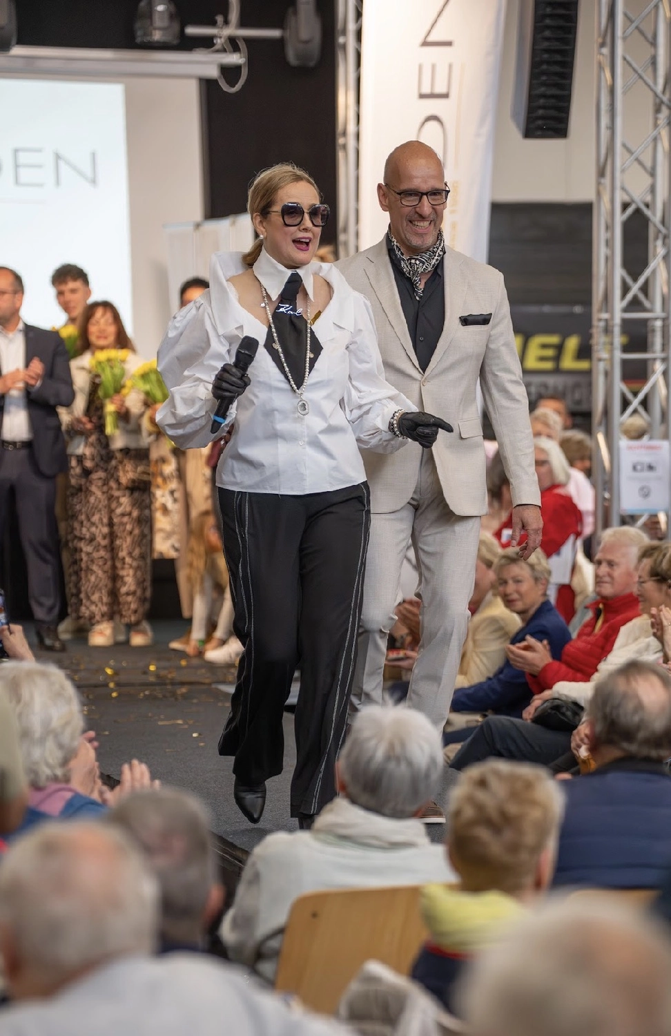 Abig-Moden - Modeboutique - Ein Model mit langen, lockigen Haaren posiert in einem weißen T-Shirt mit dem fettgedruckten schwarzen Schriftzug „LOVE ON TOP“ unter der Überschrift „10 DAYS“.